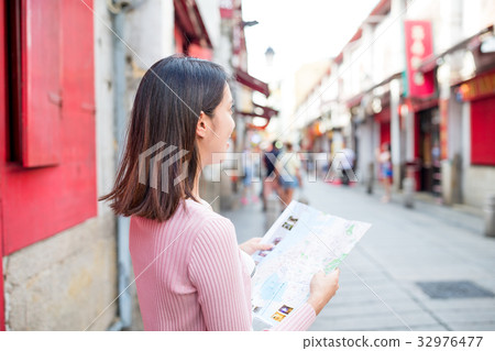 Woman looking at city map in Rua da Felicidade of Macao city 32976477