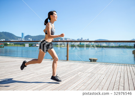 Young Woman jogging on the boardwalk Young Woman jogging on the boardwalk 32976546