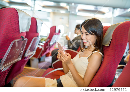 Passenger using mobile phone inside ferry Passenger using mobile phone inside ferry 32976551