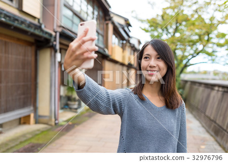 Woman taking photo by mobile phone in Kanazawa 32976796