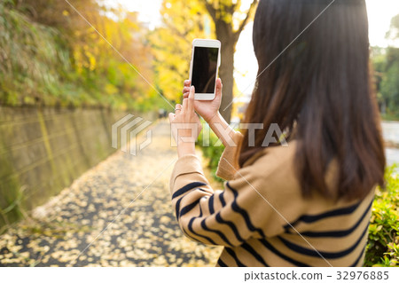 Woman capture the landscape by using mobile phone 32976885