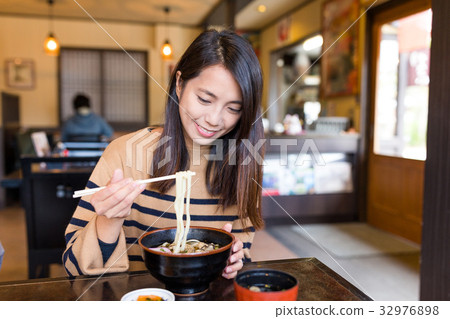 Young woman eating japanese udon in restaurant 32976898