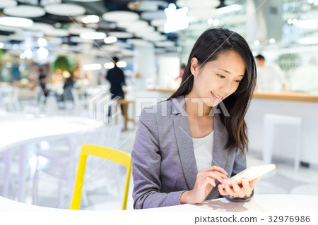 Businesswoman working on her cellphone Businesswoman working on her cellphone 32976986