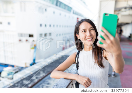 Woman taking selife by mobile phone in Cruise terminal 32977204