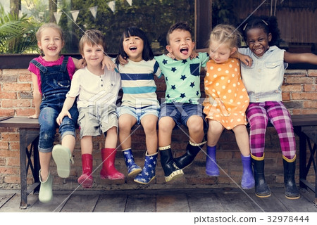 Group of kindergarten kids friends arm around sitting and smilin Group of kindergarten kids friends arm around sitting and smilin 32978444
