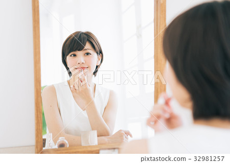 A woman applying lipstick A woman applying lipstick 32981257