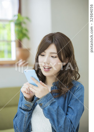 A woman watching a smartphone 32984056