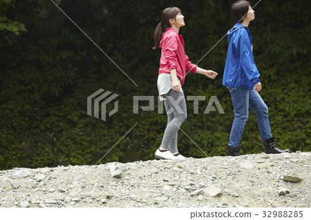 Woman walking on the riverbank 32988285