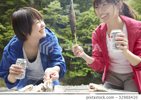 A woman enjoying a barbecue 32988410
