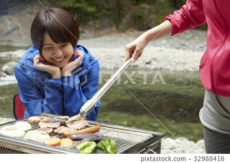 A woman enjoying a barbecue 32988416