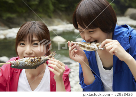 A woman enjoying a barbecue 32988426