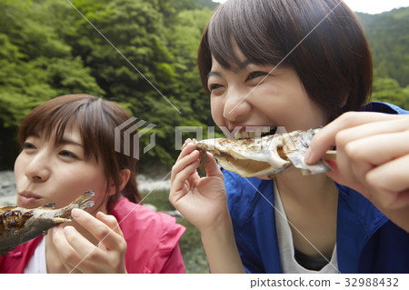 A woman enjoying a barbecue 32988432