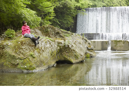 Woman relaxing at the riverbank 32988514