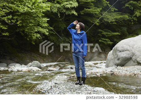 Woman walking on the riverbank Woman walking on the riverbank 32988598