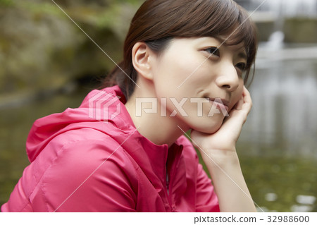 Woman relaxing at the riverbank Woman relaxing at the riverbank 32988600