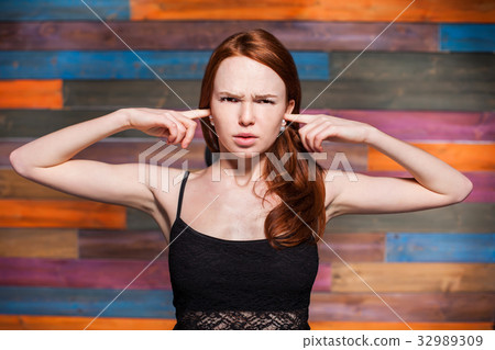 young teenage covering her ears with your fingers 32989309