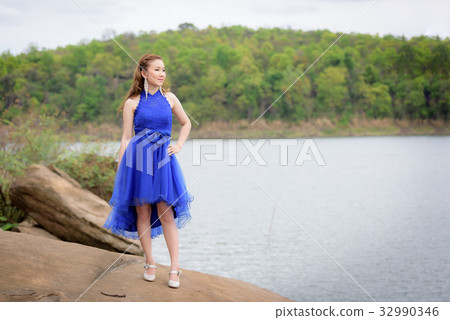 woman wear blue evening dress over mountains 32990346
