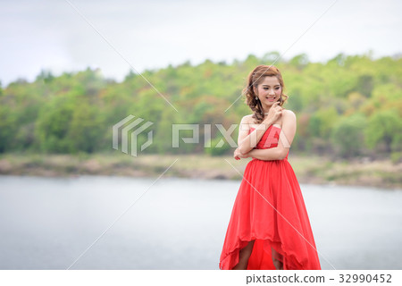woman wear red evening dress over mountains 32990452