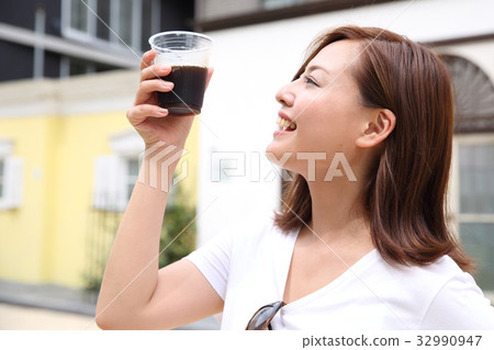 A woman drinking iced coffee 32990947