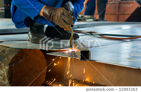 Man cutting metal with a welding cutting torch 32993263
