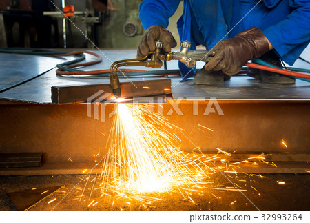 Man cutting metal with a welding cutting torch 32993264