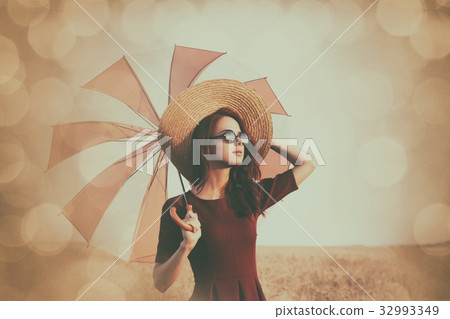 Girl in red dress with umbrella and hat 32993349