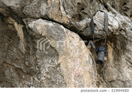 Old camera hanging on the rock Old camera hanging on the rock 32994980