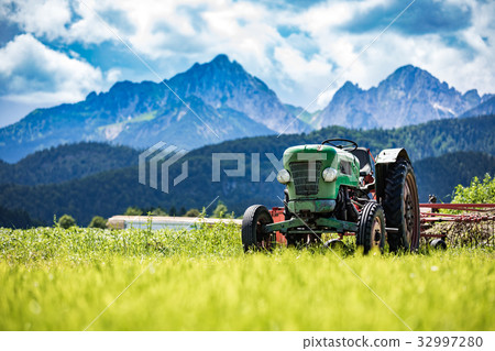 Old tractor in the Alpine meadows 32997280
