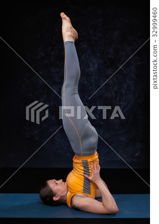 Woman doingh Ashtanga Vinyasa Yoga inverted asana 32999460