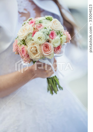 Bride holding her wedding bouquet with roses. Bride holding her wedding bouquet with roses. 33004023