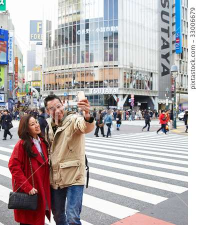 A picture of a couple taking photo together on a street A picture of a couple taking photo together on a street 33006679