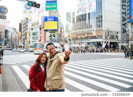 A man and his wife are taking photo together on a street A man and his wife are taking photo together on a street 33006684