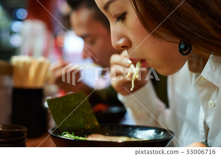 A portrait of a woman eating ramen A portrait of a woman eating ramen 33006716