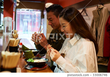 a couple is holding chopsticks and preparing to eat a couple is holding chopsticks and preparing to eat 33006746