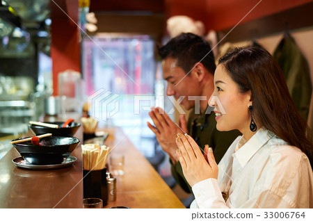 a couple is praying when sitting at a restaurant a couple is praying when sitting at a restaurant 33006764