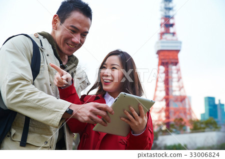 A couple is smiling when looking at their digital tablet 33006824