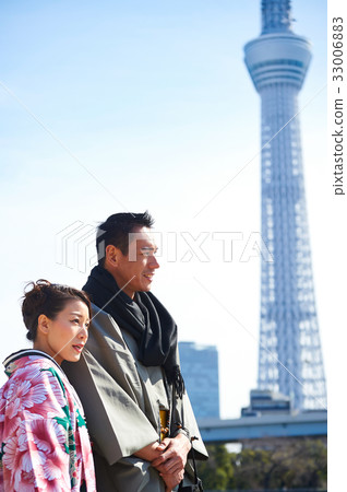 a couple is looking something near tokyo tower a couple is looking something near tokyo tower 33006883