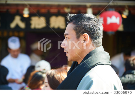 The portrait of a man standing near ramen shop 33006970