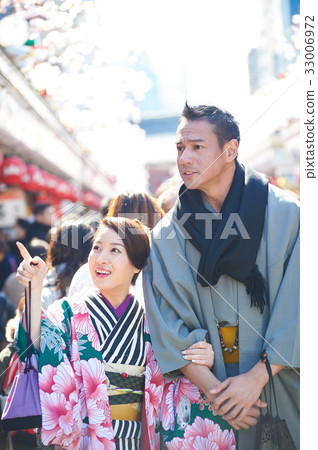 A young couple in kimono is walking happily outside. 33006972