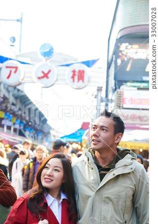 a photo of a happy couple looking at something on a street 33007028