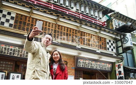 a photo of a couple smiling and taking a photo. 33007047