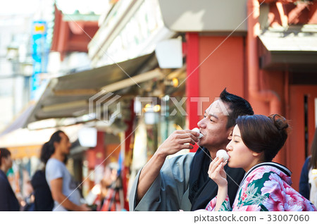 a photo of a couple eating Japanese food. 33007060