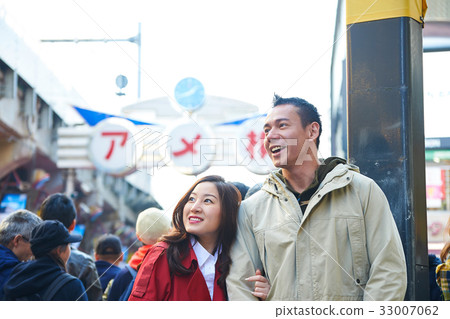 a photo of a couple smiling and looking at something. 33007062