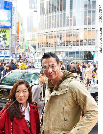 two people are standing outside of the crowded street two people are standing outside of the crowded street 33007074