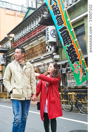 a girl is holding her boyfriend's hand and pointing at something a girl is holding her boyfriend's hand and pointing at something 33007102