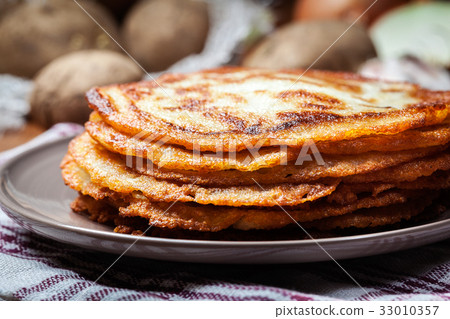 Stack of potato pancakes on a wooden table 33010357