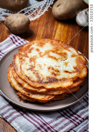 Stack of potato pancakes on a wooden table 33010358