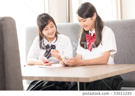 Junior high school girls doing address exchange on smartphones 33011285
