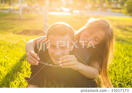 attractive couple of teenagers lying in the grass attractive couple of teenagers lying in the grass 33017173