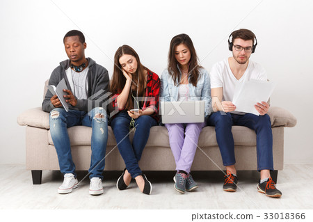 Young diverse people listen to music with gadgets Young diverse people listen to music with gadgets 33018366